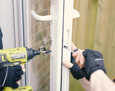 Locksmith drilling a residential door lock in Tuscaloosa